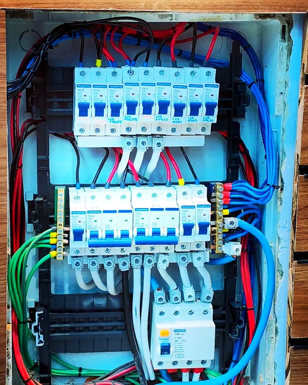 Quadro de distribuição com disjuntores identificados e fiação organizada